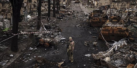 FILE: A Ukrainian serviceman stands amid destroyed Russian tanks in Kyiv. ( Photo | AP )