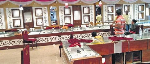 The staff of the jewllery shop look at the empty displays and shelfs after the robbers decamped with the loot ornaments in Vyasanagar, on Monday | Express