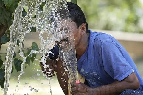 FILE - A person sprays water on his face from an irrigation pipe to beat the intense heat wave in Lucknow in the the Indian state of Uttar Pradesh, April 19, 2023. (Photo | AP)