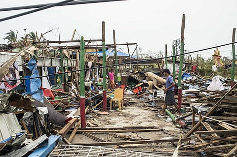 Local residents walk past damaged buildings after Cyclone Mocha in Sittwe township, Rakhine State, Myanmar, Tuesday, May 16, 2023. (Photo | AP)