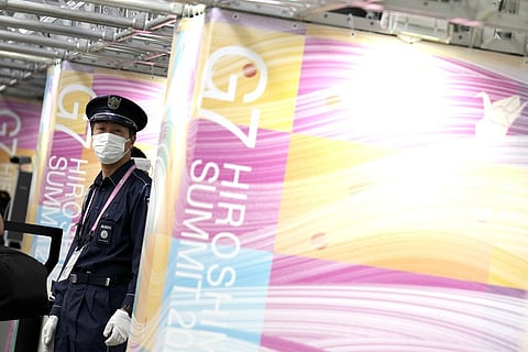 A security person stands guard as journalists queue up to enter the Media Center ahead of the Group of Seven (G-7) nations' meetings in Hiroshima, May 18, 2023. (Photo | AP)