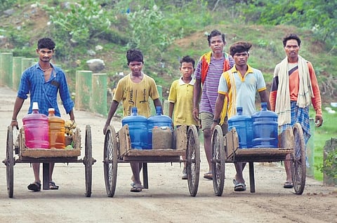 Youth seen carrying water in the hot sun in Vijayawada. (Photo I Prasant Madugula)