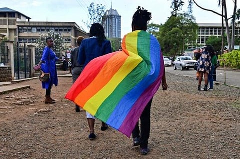 An LGBTQ community member wearing a rainbow flag leaves the Milimani high court in Nairobi, Kenya. (File Photo | AFP)