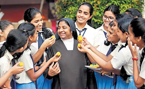 Students of St Teresa’s Convent Girls Higher Secondary School celebrate after the announcement of SSLC exam results by offering sweets to their principal | T P Sooraj