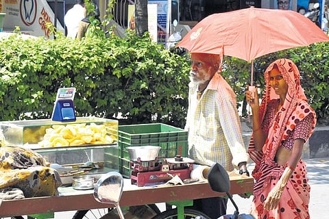 Image used for representational purposeA vendor couple taking shelter under an umbrella on a hot summer day | Madhav K