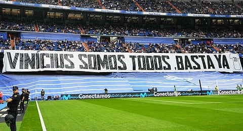 Spectators sit behind a banner reading 'We're all Vinicius' prior to a Spanish La Liga match between Real Madrid and Rayo Vallecano at the Santiago Bernabeu stadium in Madrid.