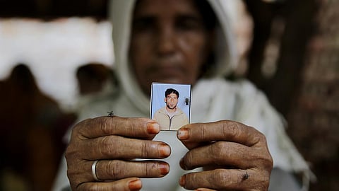 Kareeman Bano holds a photograph of her son-in-law Rakbar Khan, who died after being lynched by a mob on suspicion of cattle smuggling, in Rajasthan in 2018. (File | AP)