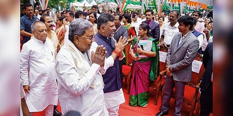 Karnataka Chief Minister Siddaramaiah with Deputy Chief Minister DK Shivakumar greets during the swearing-in ceremony of newly-inducted cabinet ministers at Raj Bhavan, in Bengaluru. (Photo | PTI)