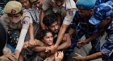Security personnel detain wrestler Vinesh Phogat during wrestlers' protest march towards new Parliament building, in New Delhi. (Photo | PTI)