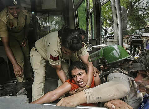 Police personnel detain wrestler Sangeeta Phogat during wrestlers protest march towards the new Parliament building, in New Delhi, Sunday, May 28, 2023. (Photo | PTI)