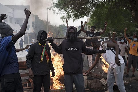 Demonstrators stand next to a barricade set on fire during a protest in support of the main opposition leader Ousmane Sonko. (Photo | AP)