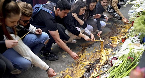 School children light candles near the Vladislav Ribnikar school in Belgrade, Serbia. (Photo | AP)