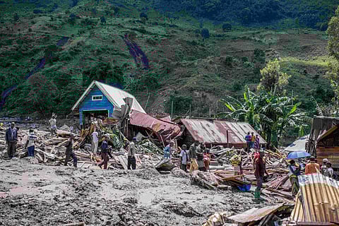 People walk next to houses destroyed by the floods in the village of Nyamukubi, South Kivu province, in Congo Saturday, May 6, 2023. ( Photo | AP )