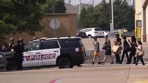 People raise their hands as they leave a shopping center following reports of a shooting, Saturday, May 6, 2023, in Allen, Texas. (Photo | AP)