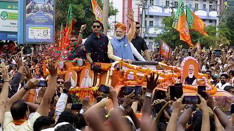 Prime Minister Narendra Modi waves at supporters during a roadshow ahead of Karnataka Assembly elections, in Bengaluru. (Photo | Shashidhar Byrappa)