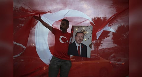FILE - A man holds a picture of Turkey's President and AKP leader Recep Tayyip Erdogan while celebrating outside the party headquarters in Istanbul, on June 24, 2018. (Photo | AP)