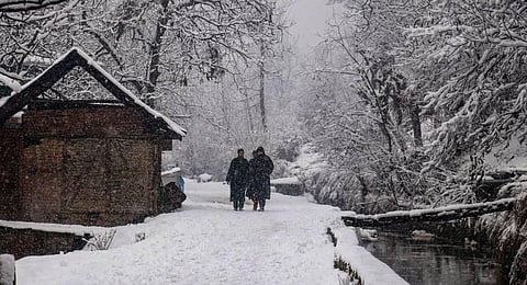 Representational Image: People walk on a snow-covered road during snowfall in Tangmarg area of North Kashmir. (File Photo | PTI)