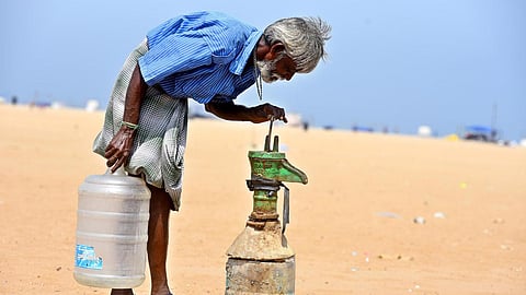 A local shop vendor checks a broken water pump for groundwater in Marina Beach, Chennai as temperatures soar in Tamil Nadu touching 40 degrees Celsius.