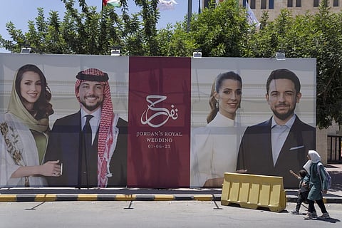 A poster with pictures of Crown Prince Hussein and his fiancee, Saudi architect Rajwa Alseif is posted at a road in Amman, Jordan. (Photo | AP)