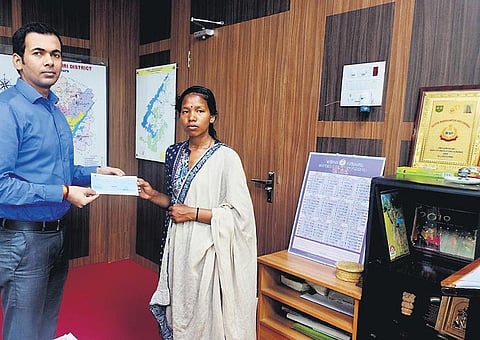 Karma Muduli receiving the cheque from collector Vishal Singh | Express