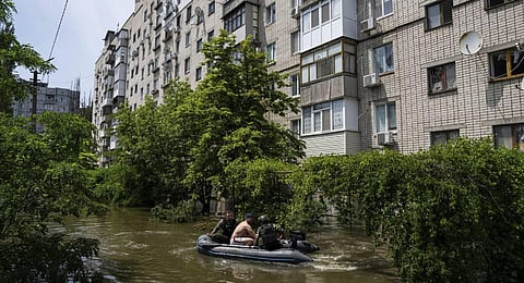 Ukrainian servicemen evacuate a man by a boat from a flooded neighborhood in Kherson, Ukraine. (Photo | AP)