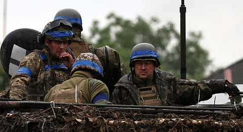Ukrainian servicemen ride atop an armoured personnel carrier vehicle (APC) in the Zaporizhzhya region. (Photo | AFP)