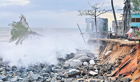A woman running to safety from rough weather and waves at Pozhiyoor on Tuesday evening.