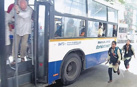 Girl students run to board a BMTC bus in Bengaluru on Tuesday | Vinod Kumar T