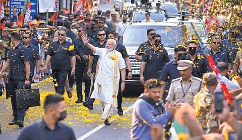 Prime Minister Narendra Modi waves at the crowd as he walks through a street in Thevara, Kochi, during a roadshow | File photo