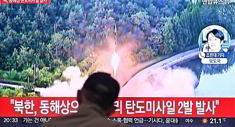 A man watches a television showing a news broadcast with file footage of a North Korean missile test. (Photp | AFP)