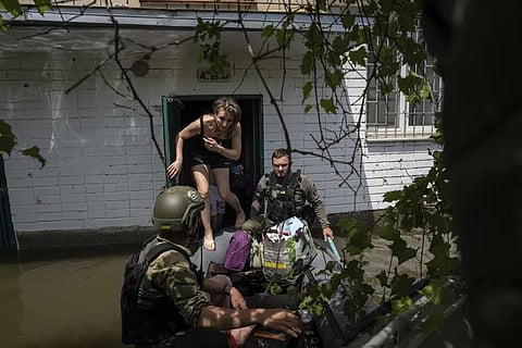 Local resident Olena gets on a small boat as she is evacuated by Ukrainian servicemen from a flooded neighborhood in Kherson, Ukraine, Thursday, June 8, 2023. (Photo | AP)