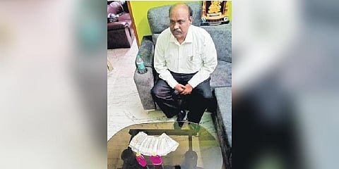 Telangana University Vice-Chancellor Dachepalli Ravinder Gupta with cash seized from him at his residence on Saturday