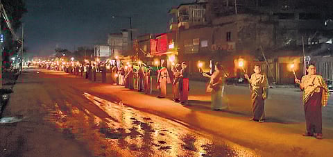 Women form a human chain to protest against the ongoing ethnic violence between Meitei and Kuki communities in Manipur, in Imphal on Saturday night. (Photo | PTI)