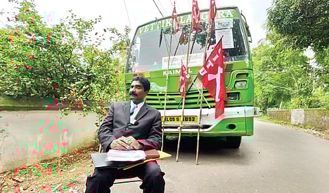 Raj Mohan selling lottery tickets in front of his bus after CITU placed flags on it