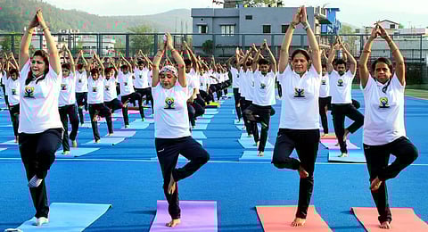 People perform yoga on the International Day of Yoga, at the Maharana Pratap Sports College, in Dehradun. (Photo | PTI)