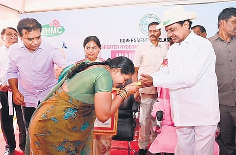 A beneficiary expresses her gratitude as Chief Minister K Chandrasekhar Rao presents her the documents for a 2BHK house in Kollur on Thursday