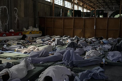 Survivors of a shipwreck sleep at a warehouse at the port in Kalamata town, about 240 kilometers (150 miles) southwest of Athens. (Photo | AP)