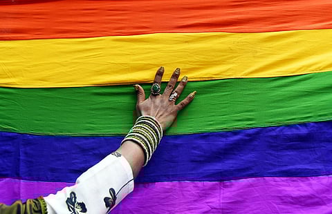 A participant lays their hand on a pride flag at a rally for celebrating the beginning of Pride Month (P Ravikumar | EPS)