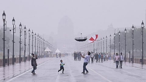 A family enjoys themselves at Kartavya Path as the southwest monsoon brings the season’s first rains in Delhi. (Photo | Parveen Negi, EPS)