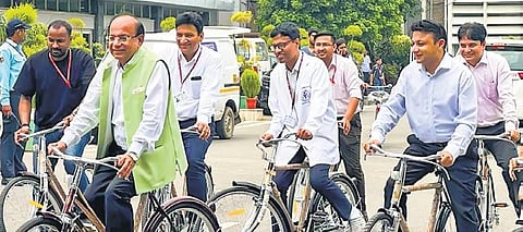 AIIMS, Delhi Director M Srinivas (C) rides a bicycle donated by EPACK Durable. (Photo | PTI)