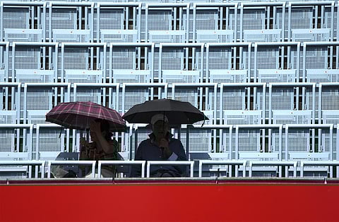 Two people hold umbrellas as they attend the WTA tournament semifinal tennis match between Belinda Bencic from Switzerland and Maria Sakkari from Greece in Berlin, Germany. (Photo | AP)