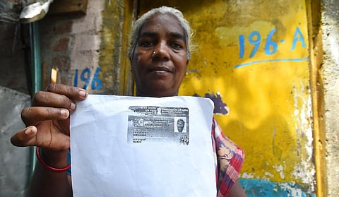 57-year-old Maari of Mattan Kuppam shows her husband’s fishing ID. (Photo | P Ravikumar, EPS) 