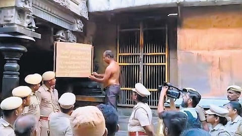 HR&CE staff removing the board placed by podhu dikshithars at the entrance of Kanagasabai at the Nataraja temple on Monday | Express
