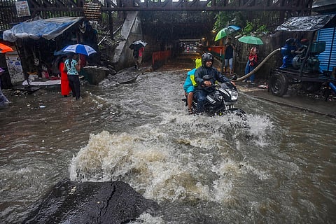 Commuters on a waterlogged road amid rain in Mumbai, Wedneaday, June 28, 2023. (PTI Photo)