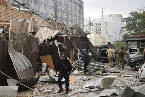 In this photo provided by the National Police of Ukraine, a police officer and a rescue worker walk in front of a restaurant RIA Pizza destroyed by a Russian attack in Kramatorsk. (Photo | AP)