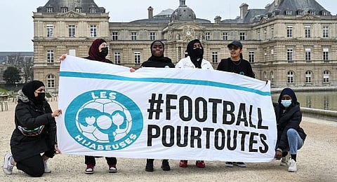 Women protestors pose with a banner reading in French '#football for all.' (Photo | AP)