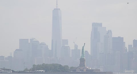 The Statue of Liberty stands in front of a hazy New York City skyline in this view from Jersey City.(Photo | AP)