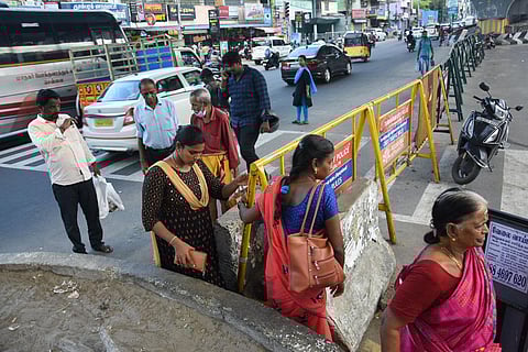 Pedestrians squeezing through barricades to cross the GST Road near Pallavaram. (Photo | Ashwin Prasath, EPS)