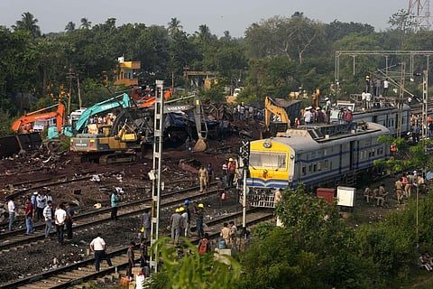 People watch the site where trains that derailed, in Balasore district, in Orissa, Sunday, June 4, 2023. (Photo | AP)