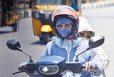 A woman and her child cover themselves completely to beat the heat at Annasalai in Chennai on Friday | P Jawahar
